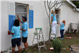 Photos of volunteers painting houses at NET event