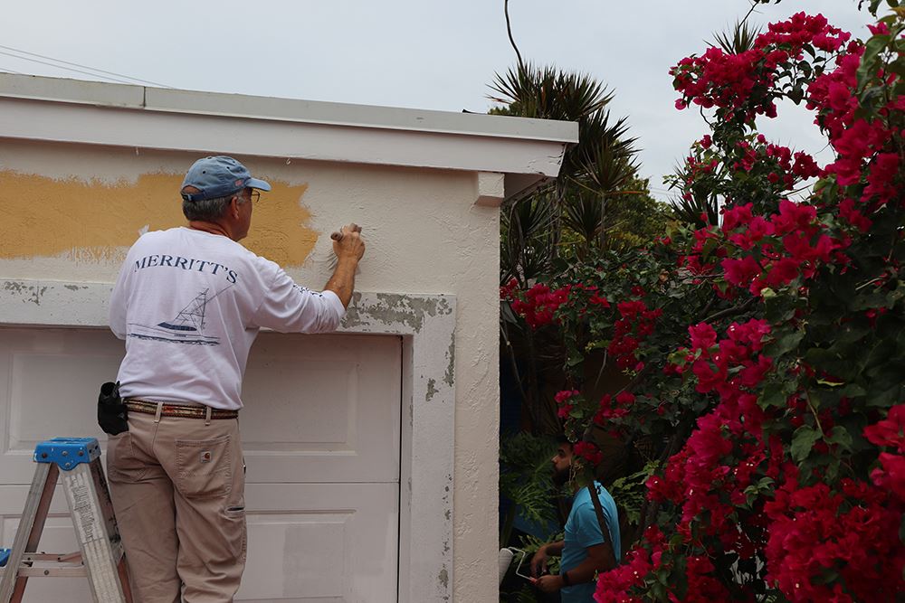 Photos of volunteers painting houses at NET event
