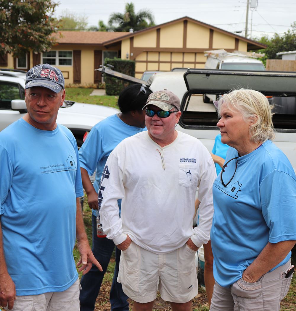Photos of volunteers painting houses at NET event