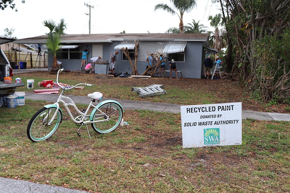 Photos of volunteers painting houses at NET event