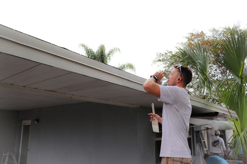 Photos of volunteers painting houses at NET event