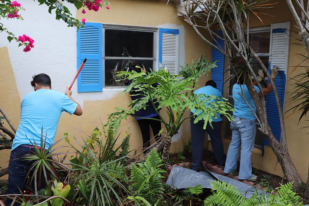 Photos of volunteers painting houses at NET event