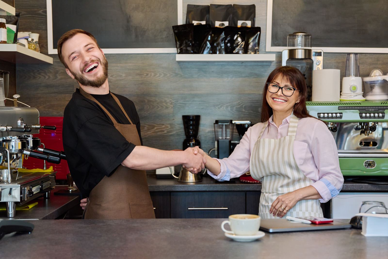 New business owners shake hands as entrepreneurs of coffee shop
